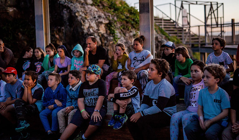 A group of students listening to their guide on a Muttonbirds by moonlight school excursion. Photo: And the Trees Photography &copy; DPIE