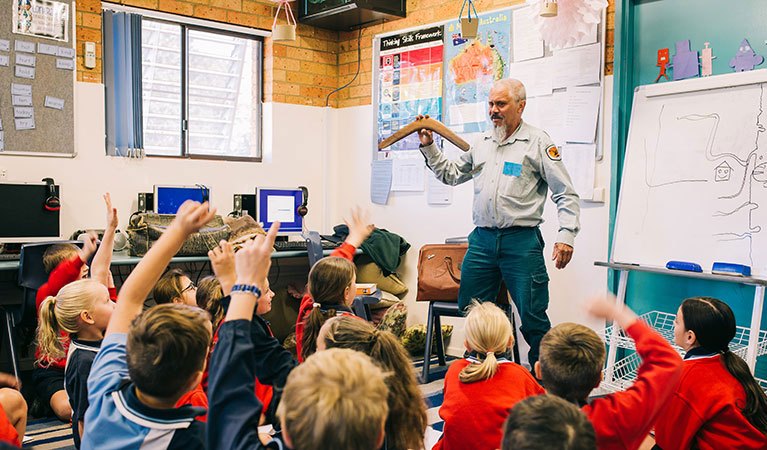 A group of school children in a classroom, learning about the Gumbaynggir People with an Aboriginal guide. Photo: And the Trees Photography © DPIE