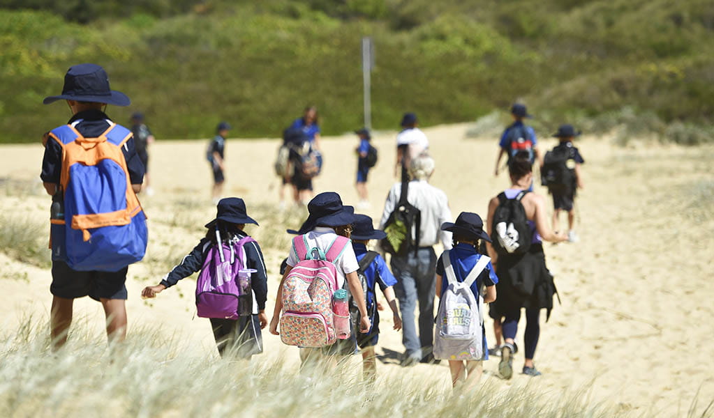 A group of students walking in the sand on a school excursion in Booti Booti National Park. Photo: Adam Hollingworth &copy; DPE 