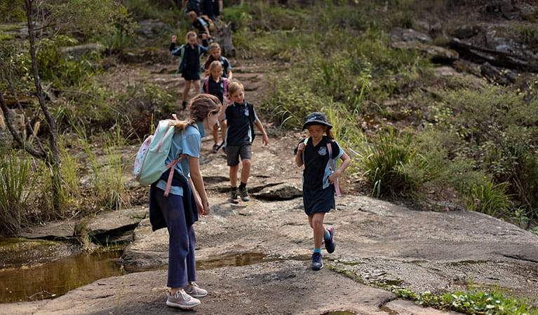 Students walking over rocks across a creek in Towarri National Park. Photo: Elana Clark &copy; DPIE