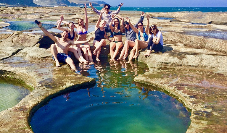 A group of friends cooling off at Figure Eight Pools, Royal National Park. Photo: Adam Hammond/Barefoot Downunder