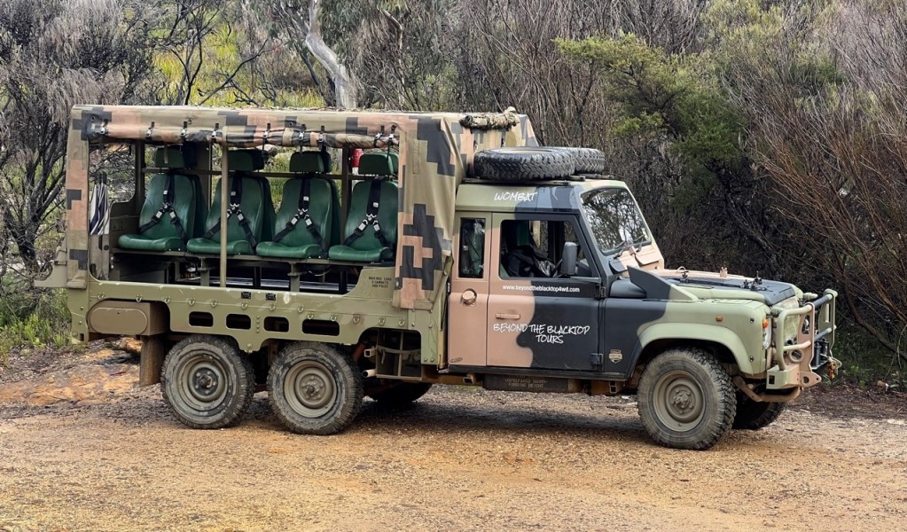 A 4WD army truck with open-air seating surrounded by bushland on a tour with Beyond the Blacktop Adventure Tours in Blue Mountains National Park. Photo: Steph Davies &copy; Beyond the Blacktop Adventure Tours