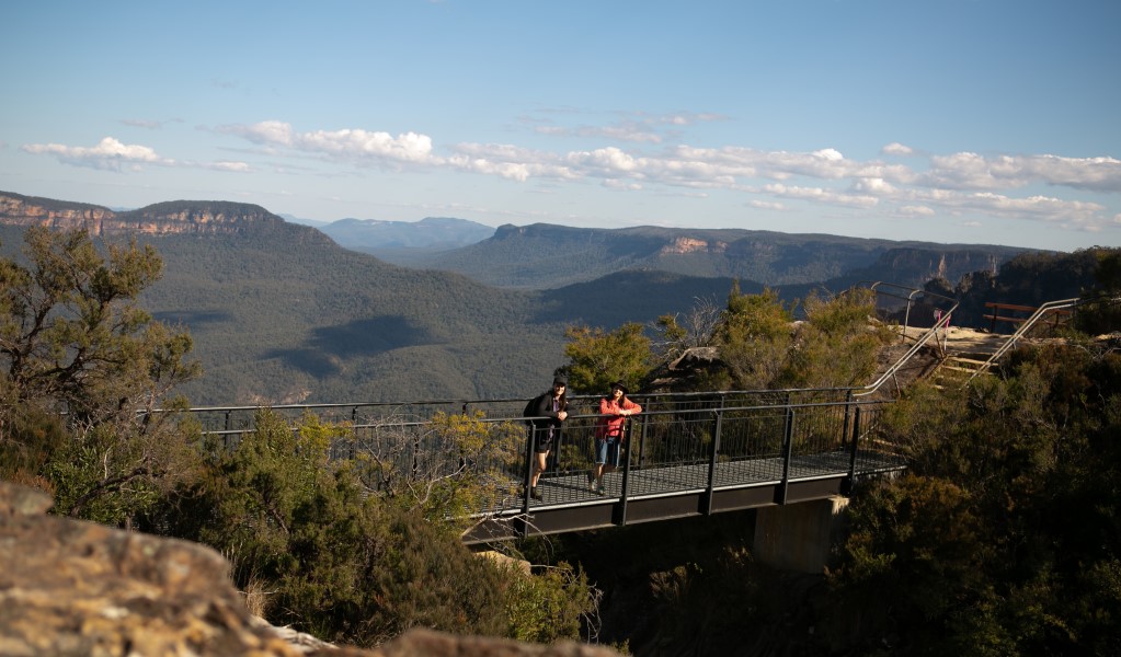 Two people enjoy views of the mountains on the Buttershaw Bridge walking platform along Grand Cliff Top Walk in Blue Mountains National Park. Photo: Jannice Banks &copy; Blue Mountains Adventure Company