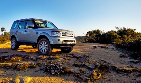 View of a Blue Mountains Eco Tours 4WD vehicle set in a rugged Blue Mountains landscape of rock and scrub. Photo credit: Paul Hartmann &copy; Blue Mountains Eco Tours