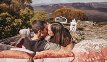 Two people kissing with view of Blue Mountains in background. Photo &copy; Blue Mountains Picnics.