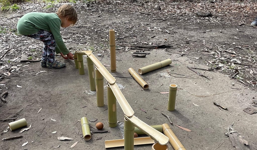 A child building a structure in nature during a Bush Play School activity. Photo: Jodie Cooper &copy; Bush Play School