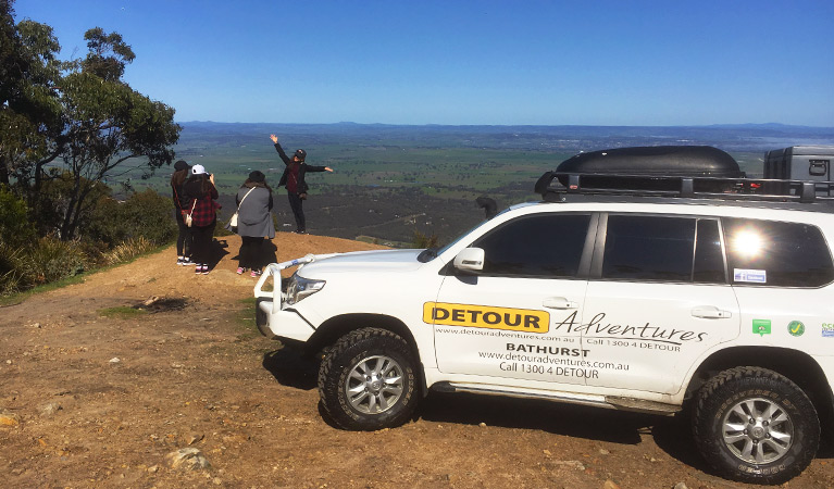 A Detour Adventures 4WD vehicle parked in front of a group of tour guests enjoying a panoramic view. Photo © Detour Adventures