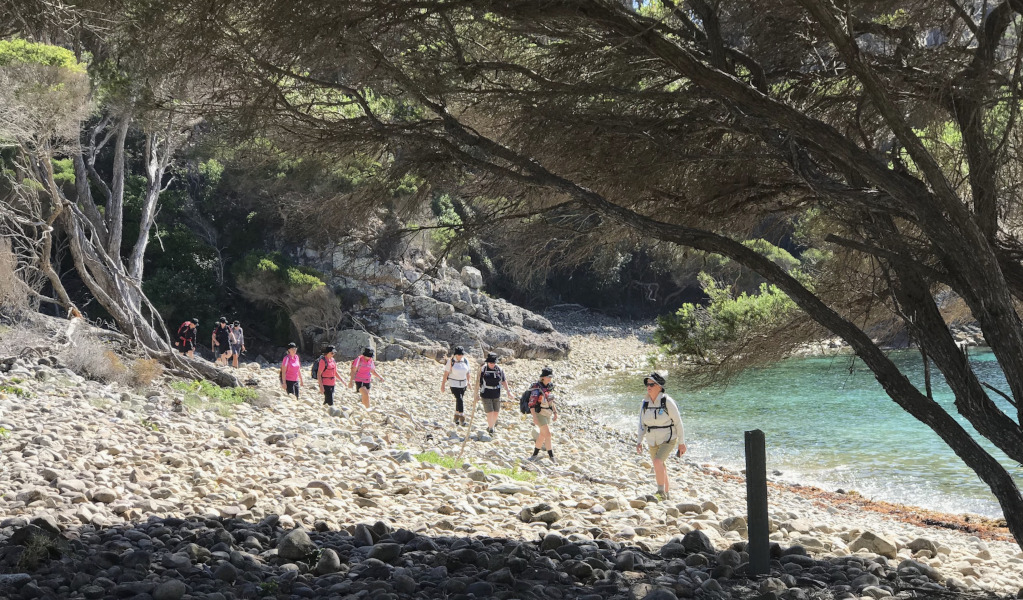 Group of women walking on rocky beach on Light to Light walk guided tour in Beowa National Park. Photo: &copy; Life's an Adventure