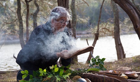 An Aboriginal guide from Minga Aboriginal Cultural Services conducting a smoking ceremony. Photo &copy; Toby Whitelaw