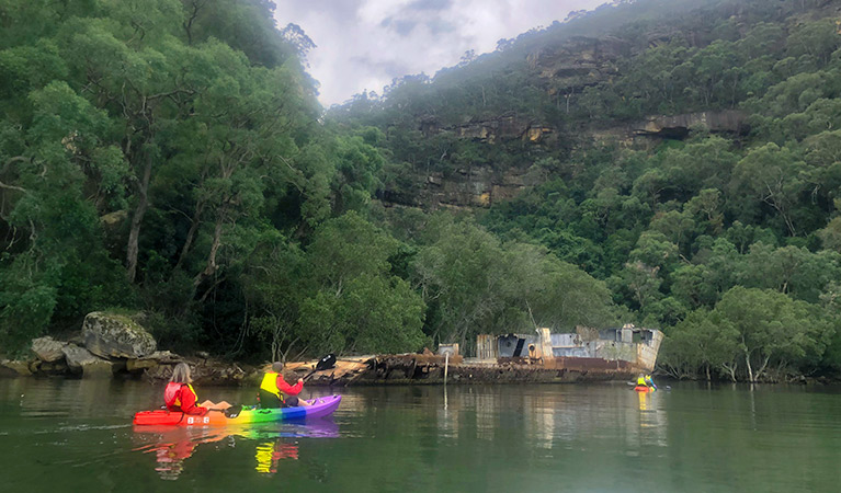 4 people in a 2 double kayaks paddle near a historic shipwreck on the Lower Hawkesbury River. Photo credit: Daniel Morrison © River Adventures