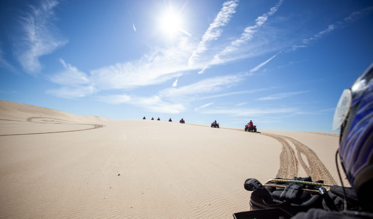 Quad bikers riding on Worimi sand dunes. Photo: Sand Dune Adventures
