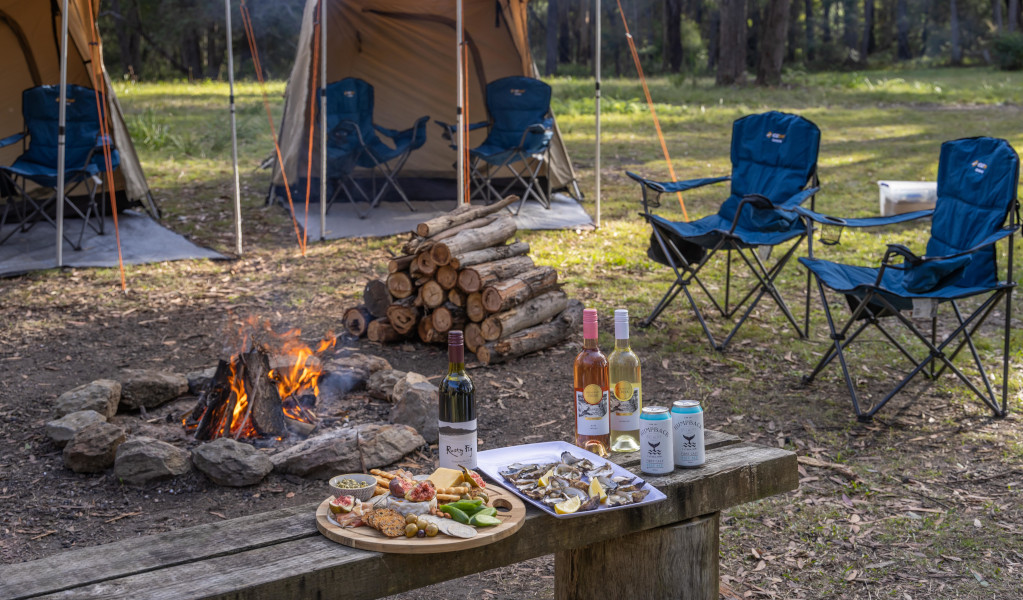 Tents and camp chairs around a fire in Beowa National Park. Photo: David Roger &copy; Tourism Australia