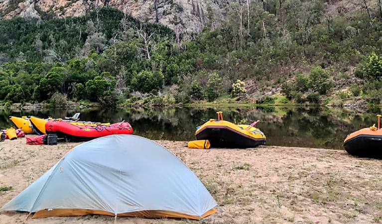Rafts and a tent pitched by the Snowy River on a guided tour with Snowy River Expeditions in Kosciuszko National Park. Photo: &copy; Snowy River Expeditions