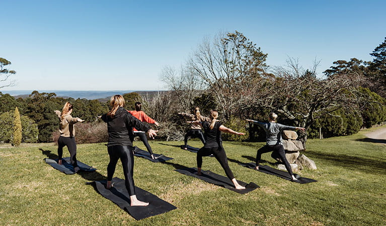 A group of people doing yoga at Solar Springs Retreat overlooking Morton National Park. Photo: Translucent Photography &copy; Solar Springs Retreat