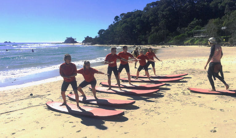A group of students practice their surf stance on a beach with their Style Surfing School instructor. Photo credit: Gaz Morgan &copy; Style Surfing School 