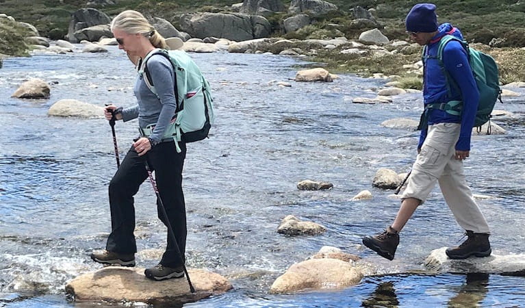 2 people crossing a river on a hiking tour in Kosciuszko National Park with Wilderness Sports. Photo: Bruce Easton &copy; Wilderness Sports