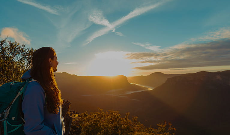 A young woman watches a dramatic sunset over the Blue Mountains.  Photo credit: Andy Lloyd &copy; Women Want Adventure
