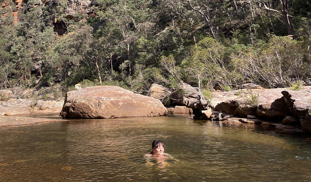 Woman swimming in Glenbrook Gorge in Blue Mountains National Park after bushwalking with Wonders of Nature Eco Tours. Credit: Hannah Bowman &copy; Wonders of Nature Eco Tours