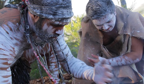 Close-up view of 2 Aboriginal men crouched over to perform a cultural ceremony. Photo credit: Menashe Salomon &copy; Zanza Tours