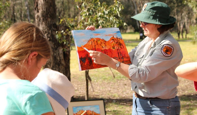 An NPWS ranger guiding children to paint the landscape in Warrumbungle National Park. Photo: S Brookhouse/OEH