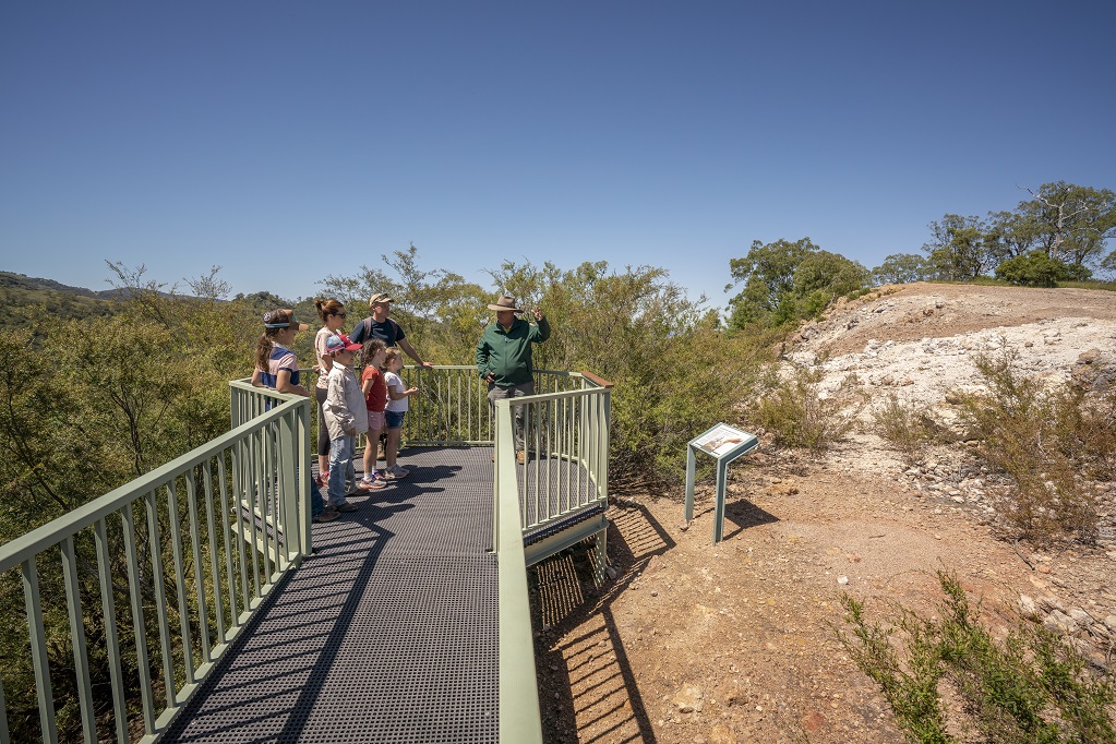 A group of people led by an NPWS guide pause on a lookout during the Burning Mountain adventure, Burning Mountain Nature Reserve. Photo credit: John Spencer © DPE
