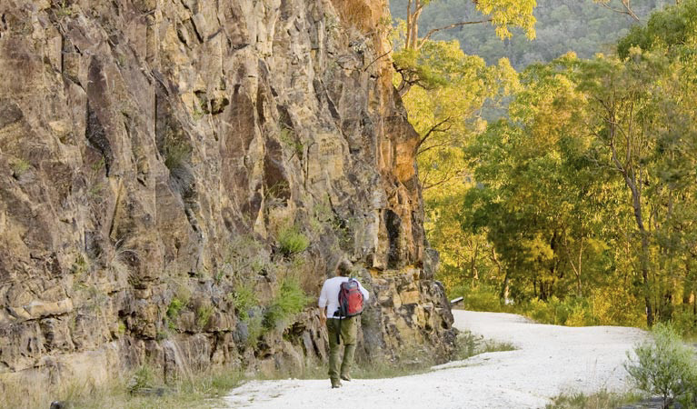 Female hiker with green pants, white shirt and red backpack on the Old Great North Road. Photo: Nick Cubbin © DPIE