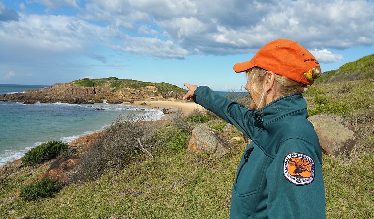 NPWS Discovery Ranger pointing out over Bournda Island lookout, Bournda National Park. Photo: 