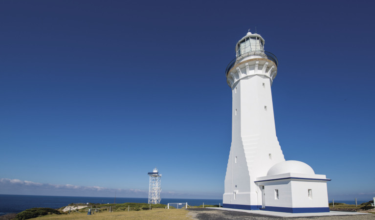 Large white light house with blue sky in background. Photo: Greg Leayr