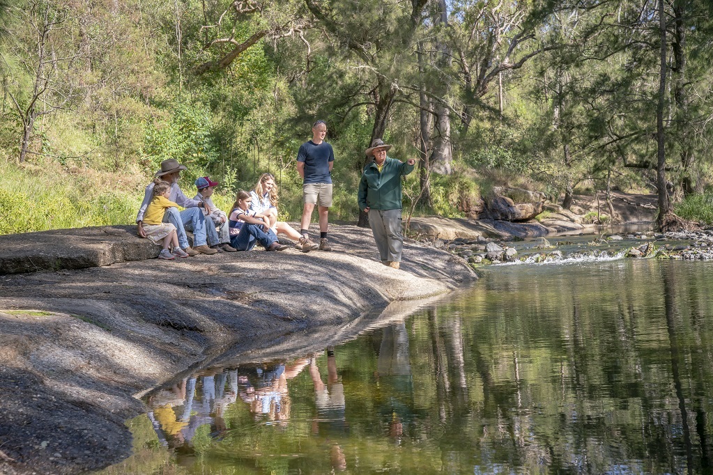 An tour group and an NPWS guide pause at Washpools to talk during the Junior ranger tour at Towarri National Park. Photo credit: John Spencer © DPE