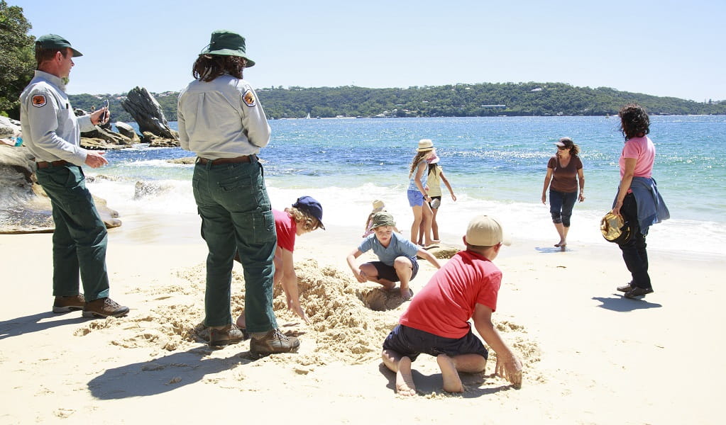NPWS Discovery rangers and a group of kids playing in the sand at the beach. Photo: Rosie Nicolai/OEH