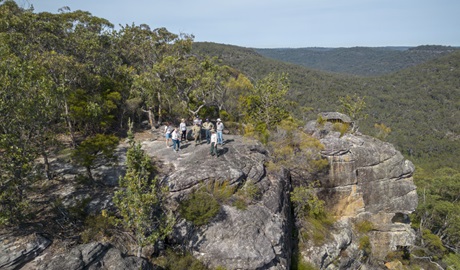 People standing on cliff edge, Muogamarra Nature Reserve. Photo: John Spencer &copy; DCCEEW