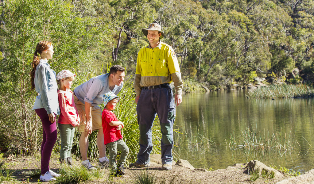 Family of four stands on river bank with NPWS ranger. Photo: Simone Cottrell &copy; DPE