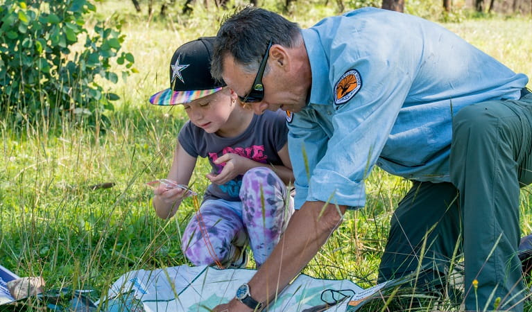 Child and NPWS ranger examine a map. Photo: John Spencer &copy; DPE 