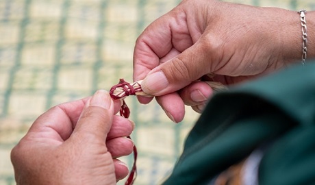 Teacher's hands demonstrating the start of weave, Bournda National Park. Photo: Jessica Bray © the photographer