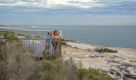 Walkers taking in panoramic coastal views from the cliff edge at Cape Solander, Kamay Botany Bay National Park. Photo: John Spencer &copy; DCCEEW