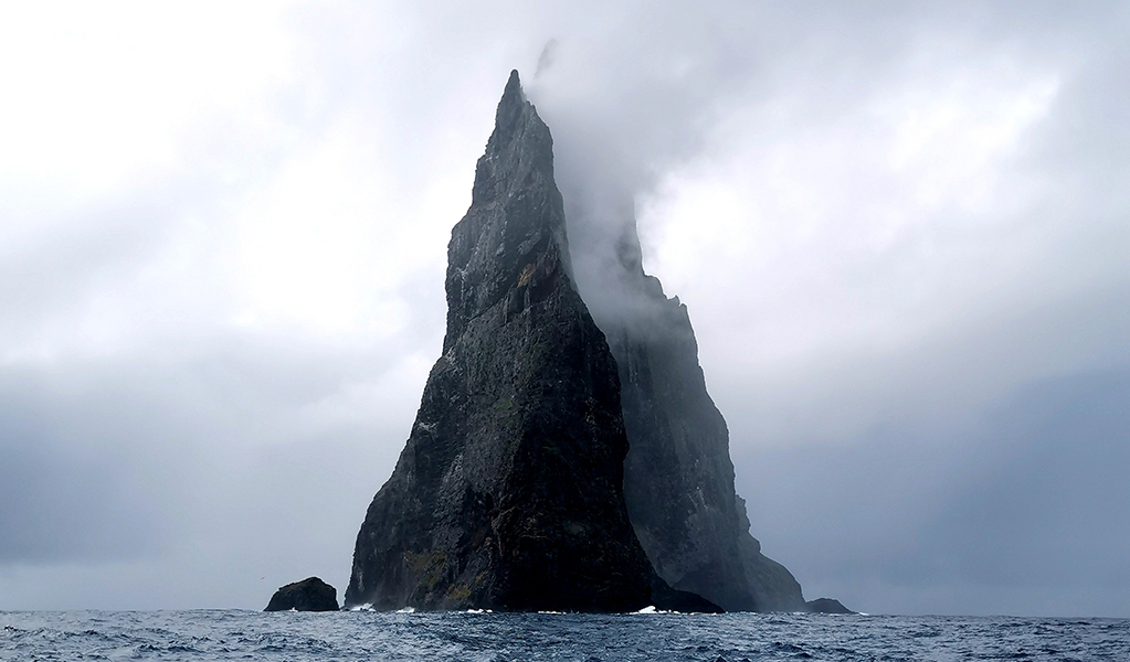 Rocky outcrop partly hidden in cloud, viewed from the water. Credit: Ava Kirkby/DPE