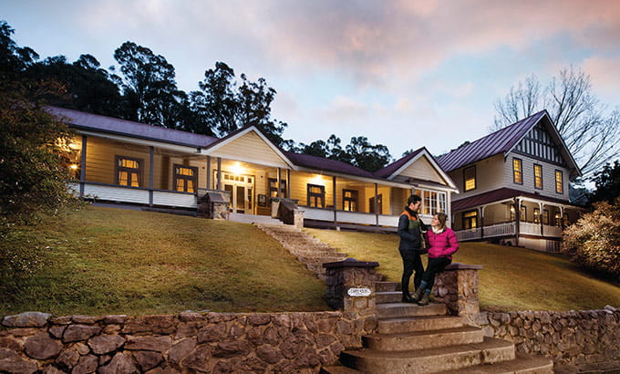 Couple on steps of Yarrangobilly Caves House in Kosciuszko National Park. Photo: M Vanderveer/OEH