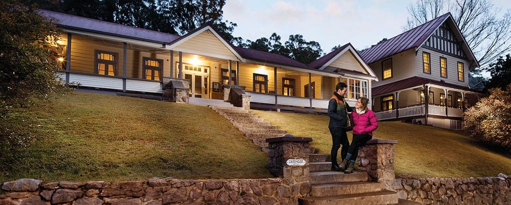 Couple on steps of Yarrangobilly Caves House in Kosciuszko National Park. Photo: M Vanderveer/OEH