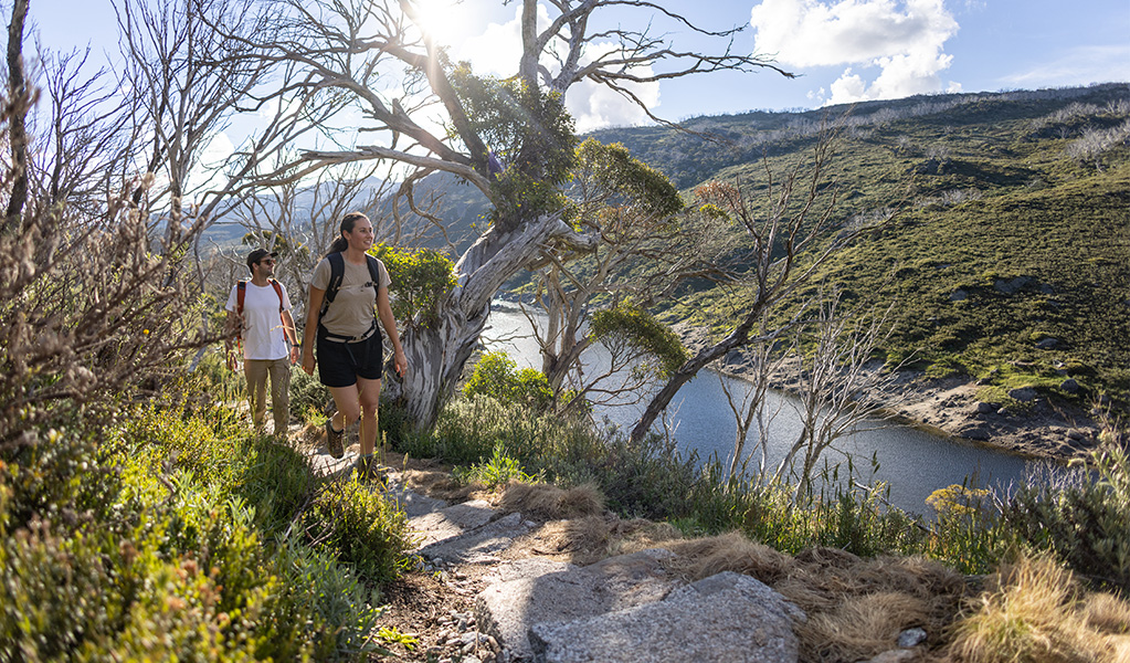 A couple walk through river valley on Guthega to Charlotte Pass walk in Kosciuszko National Park. Photo &copy; Boen Ferguson