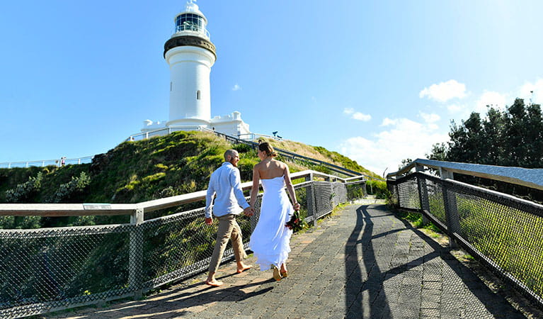 A couple walking up the path to Cape Byron lighthouse in Cape Byron State Conservation Area. Photo: Fiora Sacco &copy; DPIE
