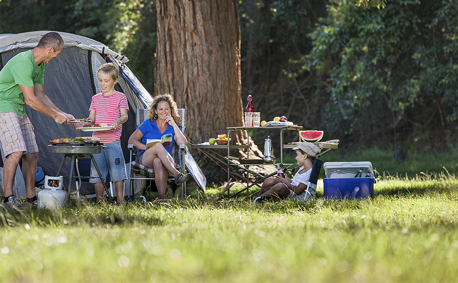 A family relaxes by their tent at the Basin campground, Ku-ring-gai Chase National Park. Photo: David Finnegan/OEH