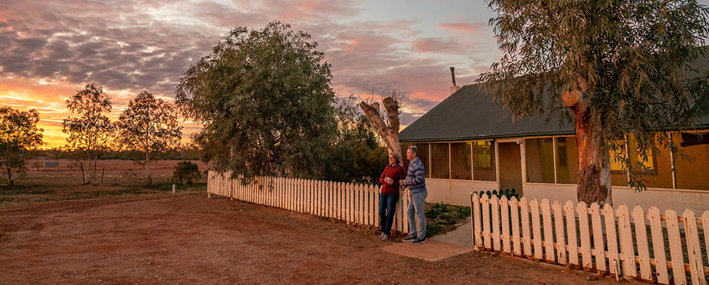 A couple watch an outback sunset outside Mount Wood Homestead, Sturt National Park. Photo: John Spencer/DPIE