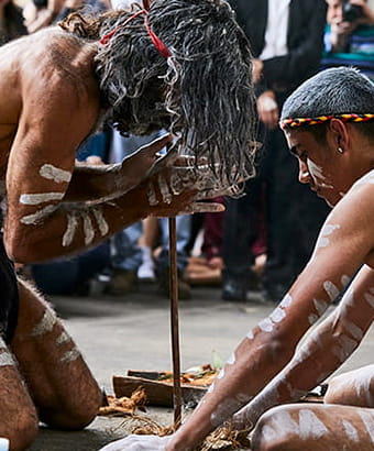 2 men share an Aboriginal cultural technique of fire starting with visitors. Flash Point Labs s &copy; Tribal Warrior