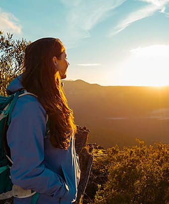 A young woman watches a dramatic sunset over the Blue Mountains. Photo credit: Andy Lloyd &copy; Women Want Adventure
