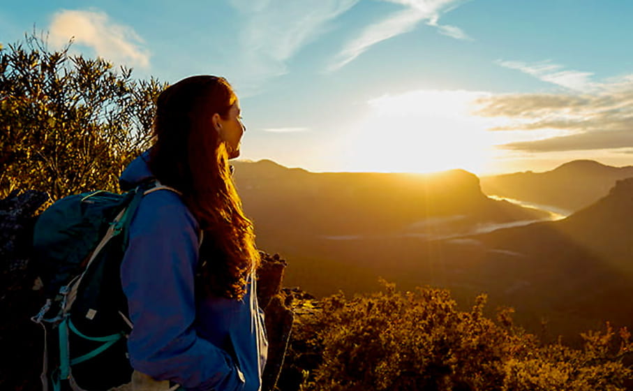 A young woman watches a dramatic sunset over the Blue Mountains. Photo credit: Andy Lloyd &copy; Women Want Adventure