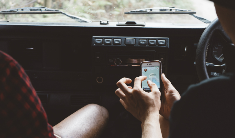 Friends using NSW National Parks app in parked car. Photo: Daniel Parsons/Caravel Content 