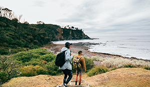 A couple walking along the coastal tracks in Murramarang National Park. Photo: Melissa Findley