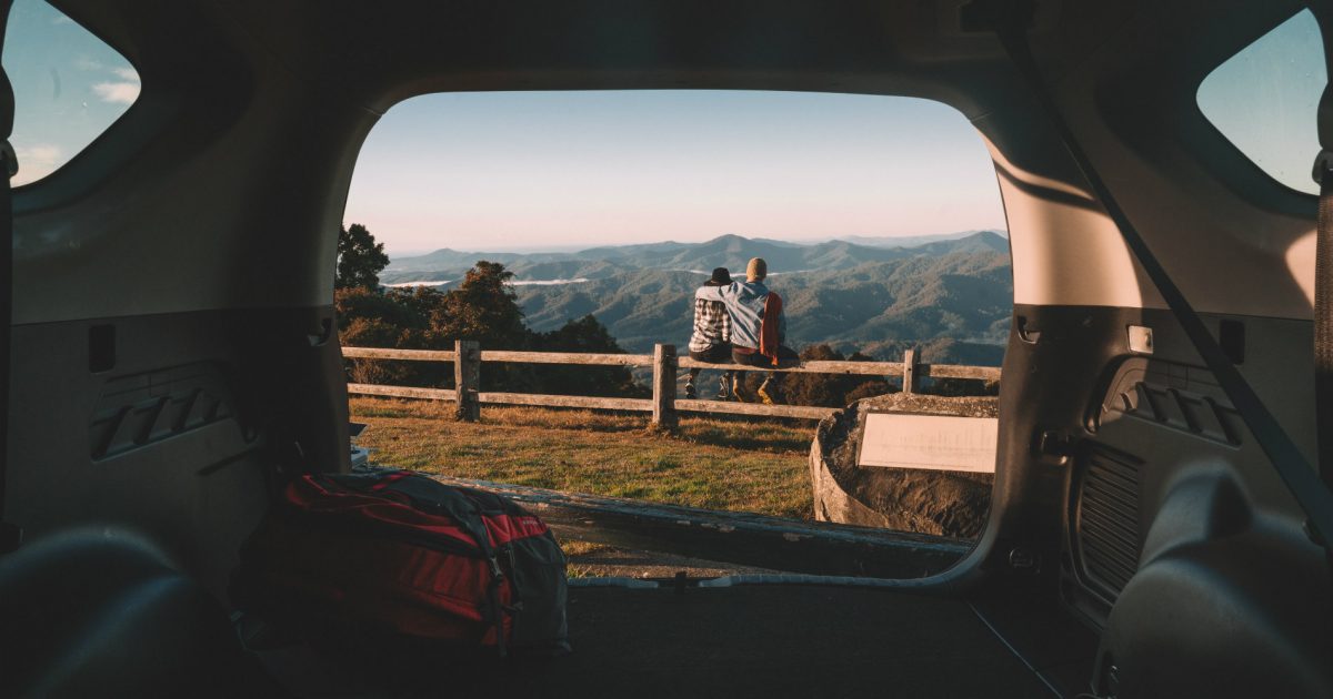 View from car of couple sitting on fence. Photo: Branden Bodman/OEH