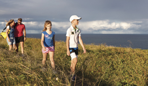 A family walk along a coastal path on Muttonbird Island Nature Reserve. Photo: R Clearly Seen Australia