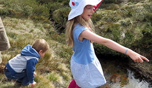 Kids looking in the river in Kosciuszko National Park. Photo: K Cooper/OEH
